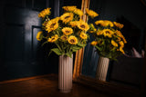 A modern Autumnal faux flower arrangement of finest quality faux sunflower stems which our team of florists have arranged into a modern white ceramic vase