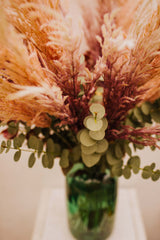 Chic artificial pampas grasses, eucalyptus and cotinus in a stylish green glass vase. Perfect for businesses, large spaces in a home or as a gift.