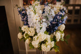 Luxury artificial delphinium, viburnum Snowball and salal foliage expertly arranged by our team of florists into a ceramic vases or available as a beautifully wrapped bouquet. Perfect for corporate and larger spaces.