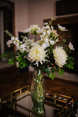 Luxury artificial white cosmos, delphinium, agapanthus and chrysanthemums mingled with the highest quality robinia and eucalyptus. Expertly arranged by our team of florists into a choice of white ceramic or green glass vase or available as a beautifully wrapped bouquet.