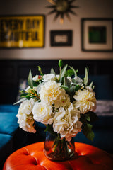 Luxury artificial peony, spray roses, dahlia and hydrangea in creamy shades blended with seeded eucalyptus and soft grey lambs ear foliage.  Available arranged in a green glass vase or as a gift wrapped bouquet.
