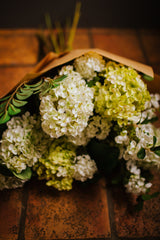 Luxury artificial hydrangea, orange blossom, viburnum and seasonal foliage. Expertly arranged by our team of florists into a tall white ceramic vase or available as a beautifully wrapped bouquet, perfect for larger spaces.