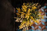An abundance of artificial mimosa, olive branches and soft grey foliage arranged in a chic off white vase or available as a gift wrapped bouquet.  Perfect for the home or to gift.
