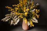 An abundance of artificial mimosa, olive branches and soft grey foliage arranged in a chic off white vase or available as a gift wrapped bouquet.  Perfect for the home or to gift.