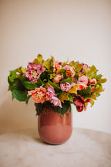 Artificial pink hellebores arranged with foliage into a sleek blush pink vase or available as a gift wrapped bouquet.  Perfect for home or to gift!