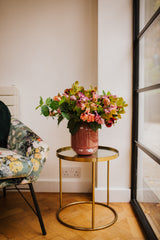 Artificial pink hellebores arranged with foliage into a sleek blush pink vase or available as a gift wrapped bouquet.  Perfect for home or to gift!