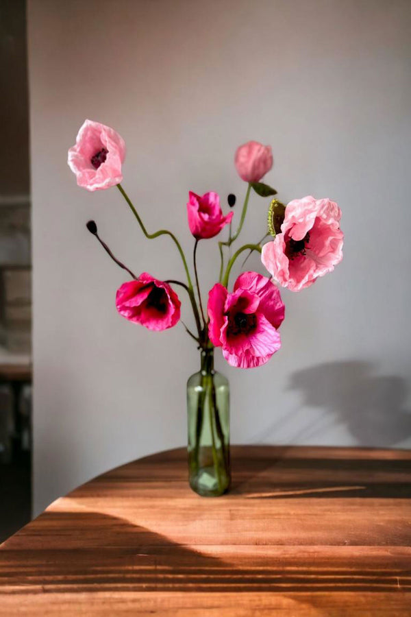 Our bold Hattie arrangement is guaranteed to inject colour, personality and energy into any space.  The joyful pink toned poppies are perfect to gift or to keep!  UNBOX & ENJOY Our skilful team of florists have styled the stems in a green glass  bottle vase or they can be made into a beautifully wrapped bouquet.  
