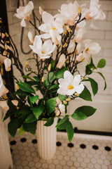 Large luxury faux floral arrangement of magnolia flowers and foliage arranged in a tall off-white vase or available as a gift wrapped bouquet.  Perfect for businesses, large spaces in a home or as a gift. 