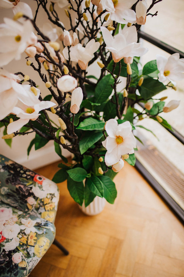 Large luxury faux floral arrangement of magnolia flowers and foliage arranged in a tall off-white vase or available as a gift wrapped bouquet.  Perfect for businesses, large spaces in a home or as a gift. 
