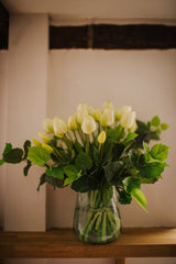 Luxury artificial white tulips and green salal foliage expertly arranged by our team of florists into a choice of light green glass or taupe metal vase or available as a beautifully wrapped bouquet. 