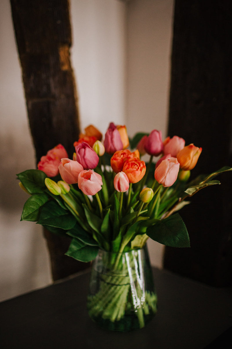 Luxury artificial tulips and salal foliage expertly arranged by our team of florists into a choice of dusky pink metal vase or light green glass vase or available as a beautifully wrapped bouquet.
