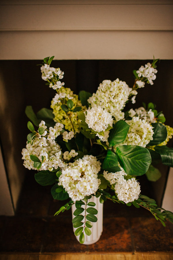 Luxury artificial hydrangea, orange blossom, viburnum and seasonal foliage. Expertly arranged by our team of florists into a tall white ceramic vase or available as a beautifully wrapped bouquet, perfect for larger spaces.