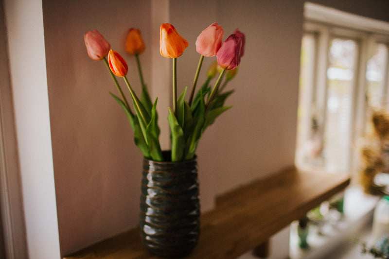 A deceptively realistic arrangement of timeless tulips. Expertly arranged by our team of florists into a green vase or available as a beautifully wrapped bouquet.
