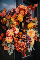 An explosion of scrumptious warm orange foliage, plum hydrangea and golden dahlia combine to create our irresistible Apple Crumble wreath.  This delicious concoction of autumnal favourites will guarantee guests a warm welcome through the winter months.