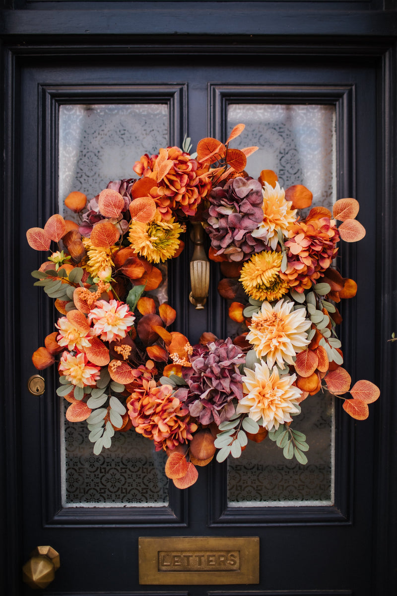 An explosion of scrumptious warm orange foliage, plum hydrangea and golden dahlia combine to create our irresistible Apple Crumble wreath.  This delicious concoction of autumnal favourites will guarantee guests a warm welcome through the winter months.