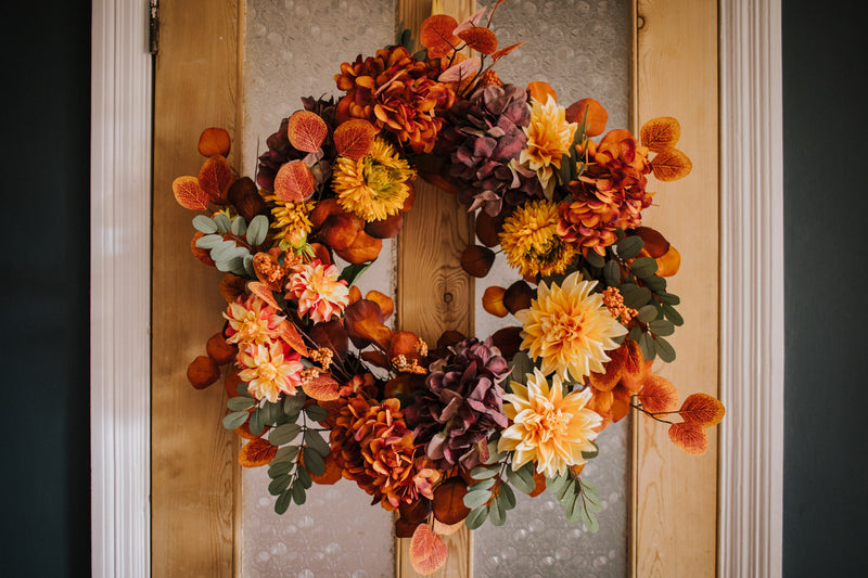 An explosion of scrumptious warm orange foliage, plum hydrangea and golden dahlia combine to create our irresistible Apple Crumble wreath.  This delicious concoction of autumnal favourites will guarantee guests a warm welcome through the winter months.