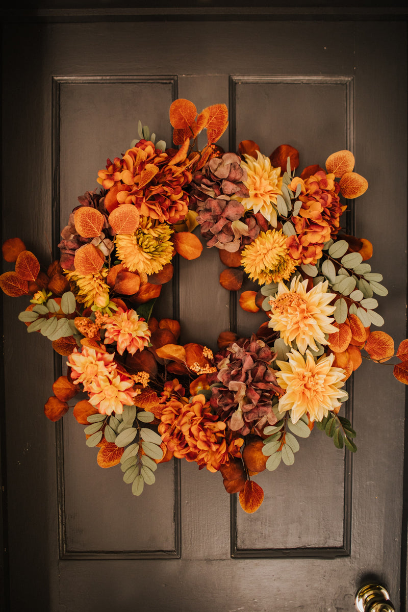 An explosion of scrumptious warm orange foliage, plum hydrangea and golden dahlia combine to create our irresistible Apple Crumble wreath.  This delicious concoction of autumnal favourites will guarantee guests a warm welcome through the winter months.
